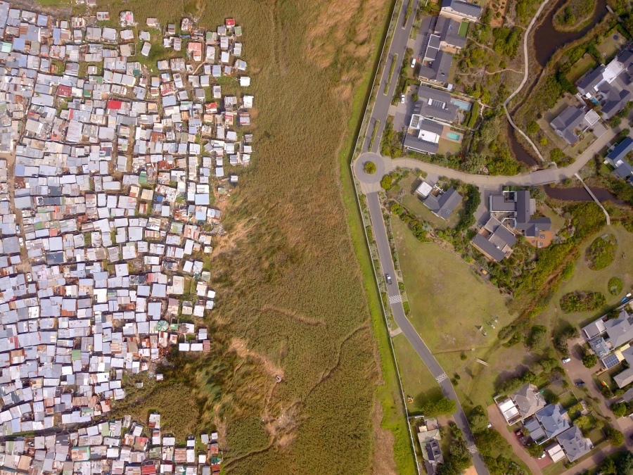 Aerial view of township and affluent suburb in South Africa divided by strip of land